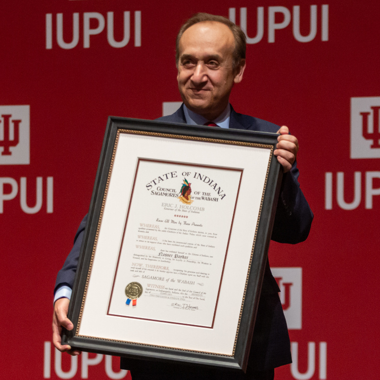 Chancellor Paydar holds a certificate during his retirement celebration
