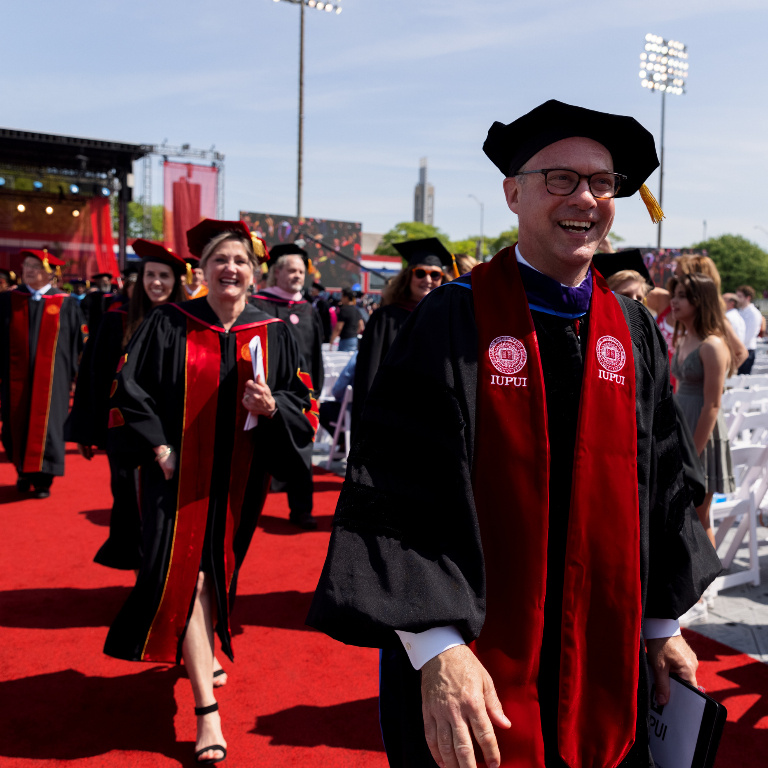 Klein and others walking after iupui commencement May 2022