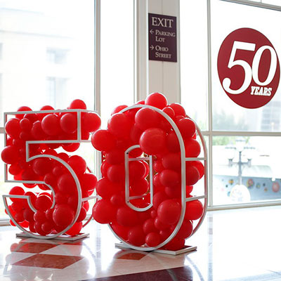 Balloon sculpture spelling out "50" for IUPUI's 50th Anniversary with the IUPUI 50th Anniversary spirit mark in the background.