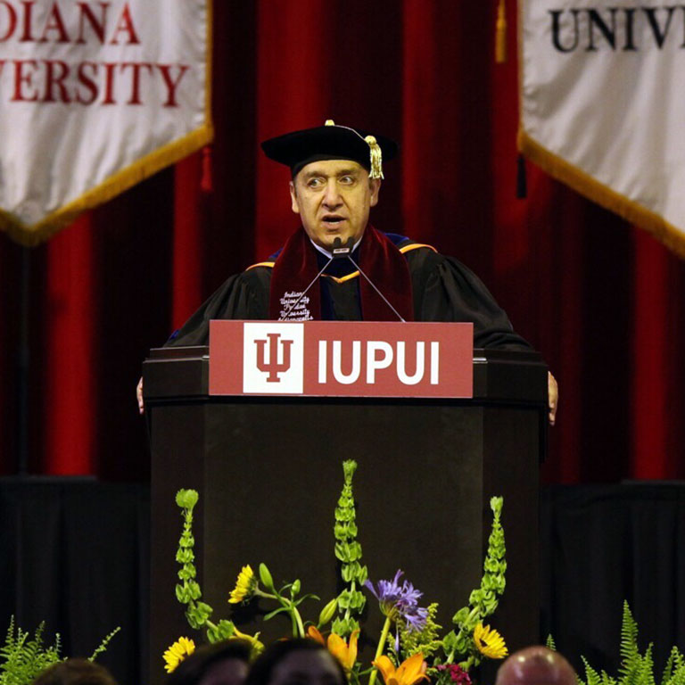 Chancellor Paydar speaking at a podium during May 2018 IUPUI Commencement
