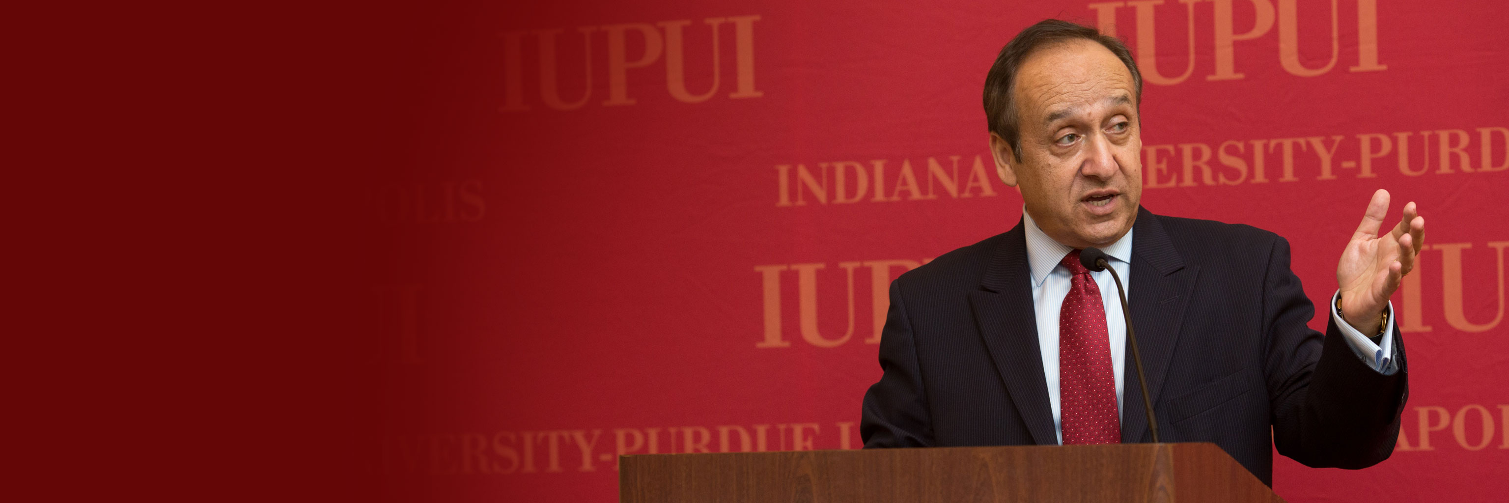 IUPUI Chancellor Nasser Paydar delivers a speech while standing at a podium.  